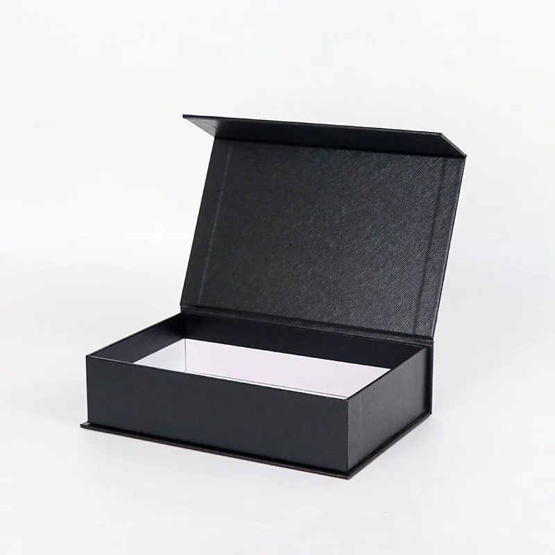Photograph of an open black book-style rigid box with hinged lid and white interior