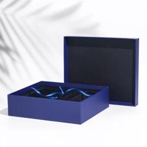 Blue rigid gift box with separate lid fitted insert and ribbon photographed on a white background